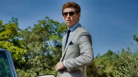 Eddie Redmayne in a dress suit as the Jackal in The Day of the Jackal.