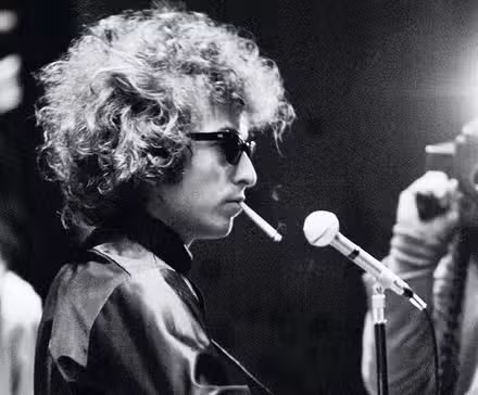 Bob Dylan performing while a camera flashes in Don't Look Back