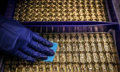 Gold prices hit a record high on a rush into safe havens and helped by the weaker dollar