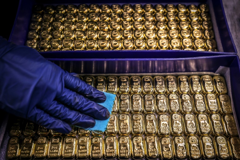 Gold prices hit a record high on a rush into safe havens and helped by the weaker dollar