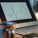 Laptop screen shows rising financial chart
