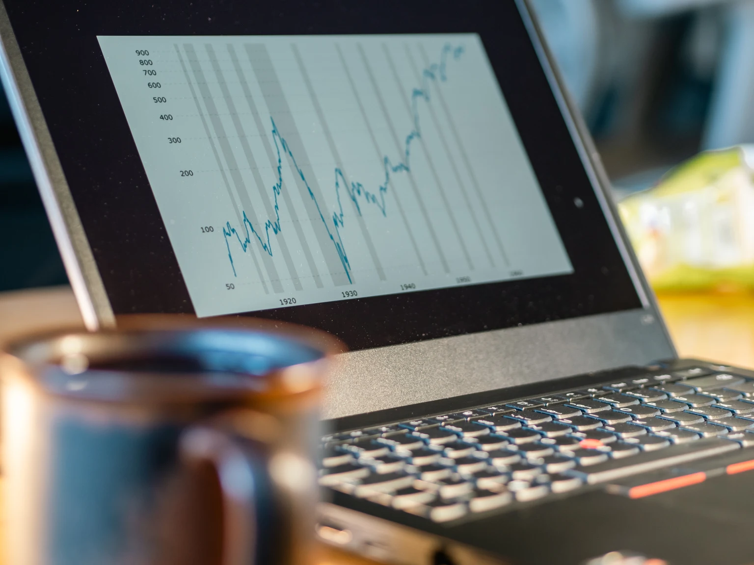 Laptop screen shows rising financial chart
