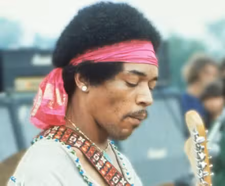 Jimi Hendrix playing guitar live during a performance.