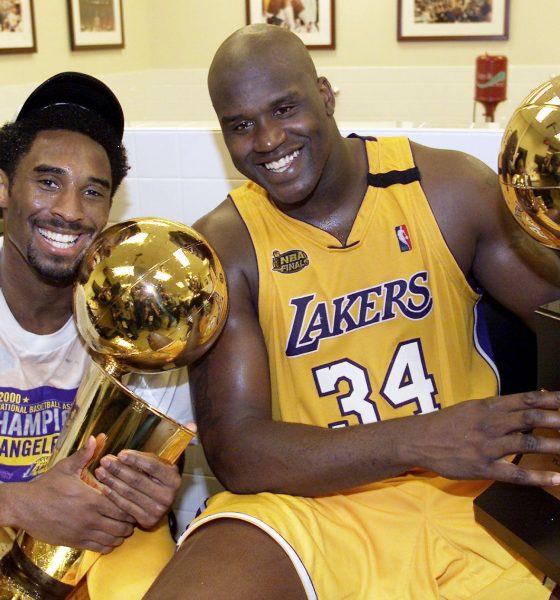 Kobe Bryant (L) of the Los Angeles Lakers holds the Larry O'Brian trophy as teammate Shaquille O'Neal (L) hold the MVP trophy after winning the NBA Championship against Indiana Pacers 19 June, 2000