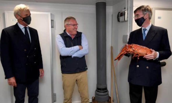 Richard Drax MP, the restaurant owner and Jacob Rees-Mogg holding a lobster