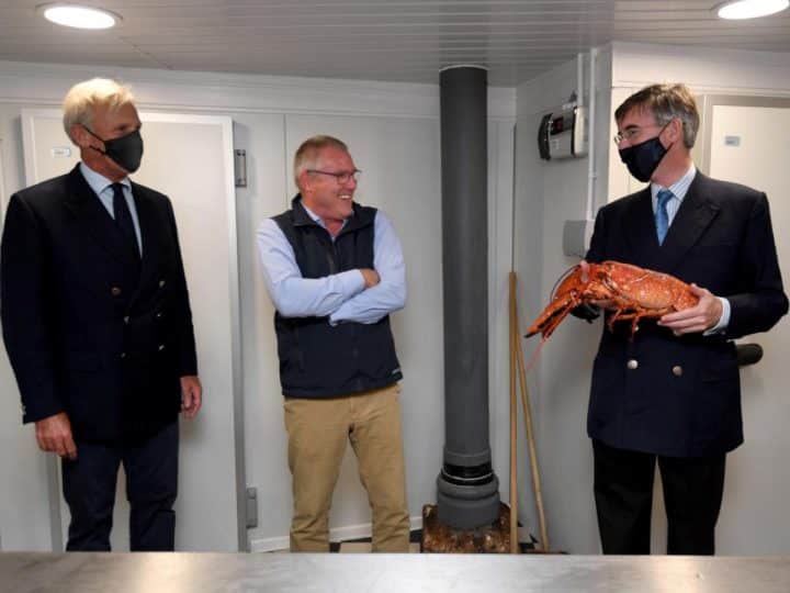 Richard Drax MP, the restaurant owner and Jacob Rees-Mogg holding a lobster
