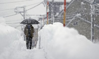 A man walks in heavy snow in Uonuma, Niigata Prefecture, on Dec. 20, 2022.