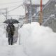 A man walks in heavy snow in Uonuma, Niigata Prefecture, on Dec. 20, 2022.