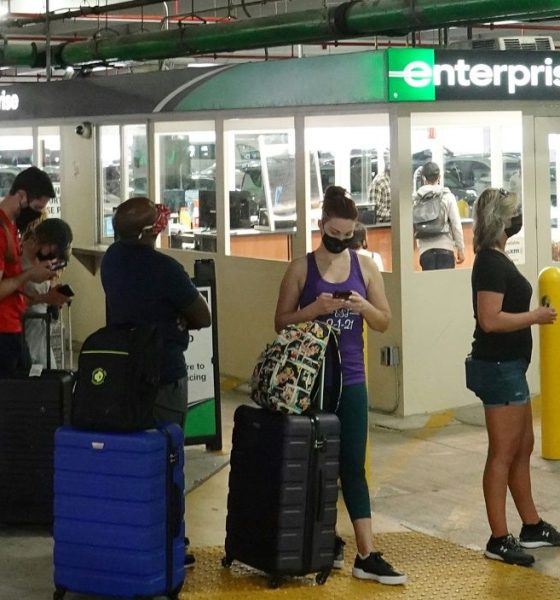 People wait in line at an Enterprise rental agency at Miami International Airport in April 2021
