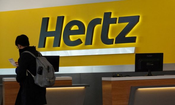 A person walks by the counter of Hertz rental car at John F. Kennedy International Airport in Queens, New York City, U.S., March 30, 2022.