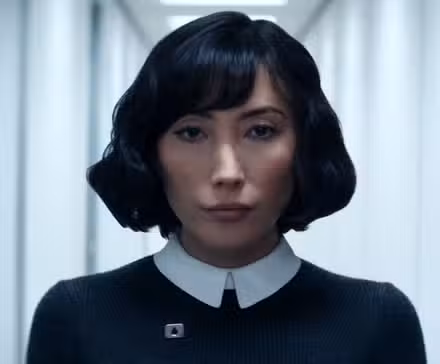 Dichen Lachman as Ms. Casey walks down a hallway in Severance Season 2.