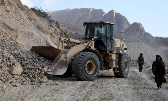An excavator clears a road following a 2025 quake in Afghanistan's Balkh province. Pic: Reuters