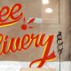 store window has hand painted (?) sign that says "free delivery"