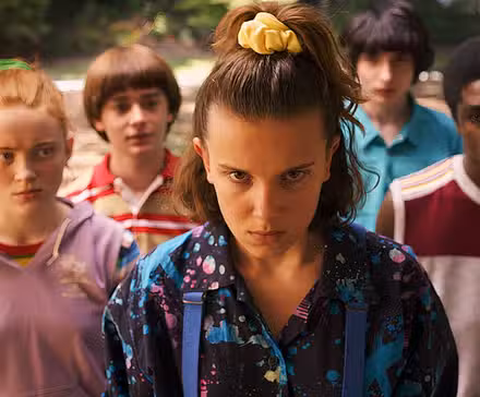 Eleven and the rest of the cast stand and look determined towards the camera in Stranger Things.