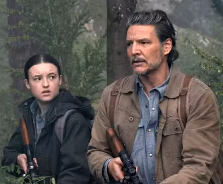 Bella Ramsey as Ellie with Pedro Pascal as Joel in the woods holding rifles in The Last of Us Season 2