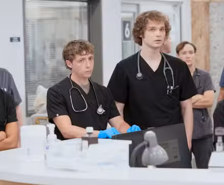 Mohan, Whitaker, Ogilvie, and Joy standing at the nurses main desk in The Pitt Season 2 Episode 7