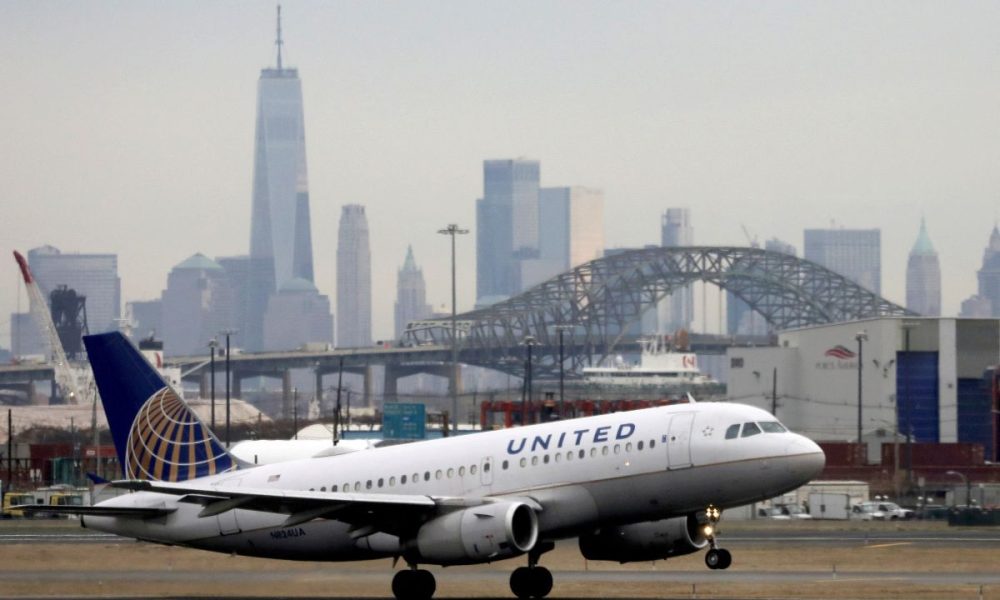 A United Airlines passenger jet takes off with New York City as a backdrop