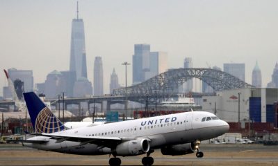 A United Airlines passenger jet takes off with New York City as a backdrop