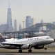 A United Airlines passenger jet takes off with New York City as a backdrop