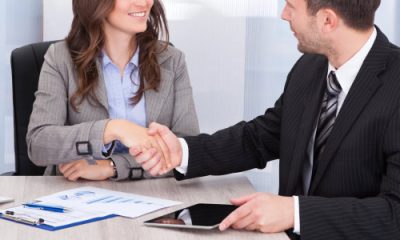 young professional woman (possibly a summer associate or law firm intern) shaking hands with an older man in a suit
