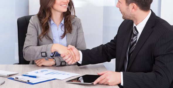 young professional woman (possibly a summer associate or law firm intern) shaking hands with an older man in a suit