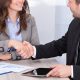 young professional woman (possibly a summer associate or law firm intern) shaking hands with an older man in a suit