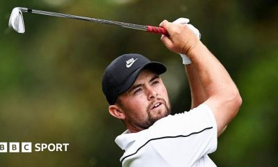 Alex Fitzpatrick watches his ball after playing an iron shot, with the club above his head