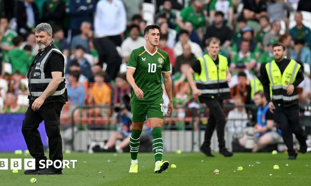 Jamie McGrath walks between tennis balls during the protest