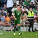 Jamie McGrath walks between tennis balls during the protest
