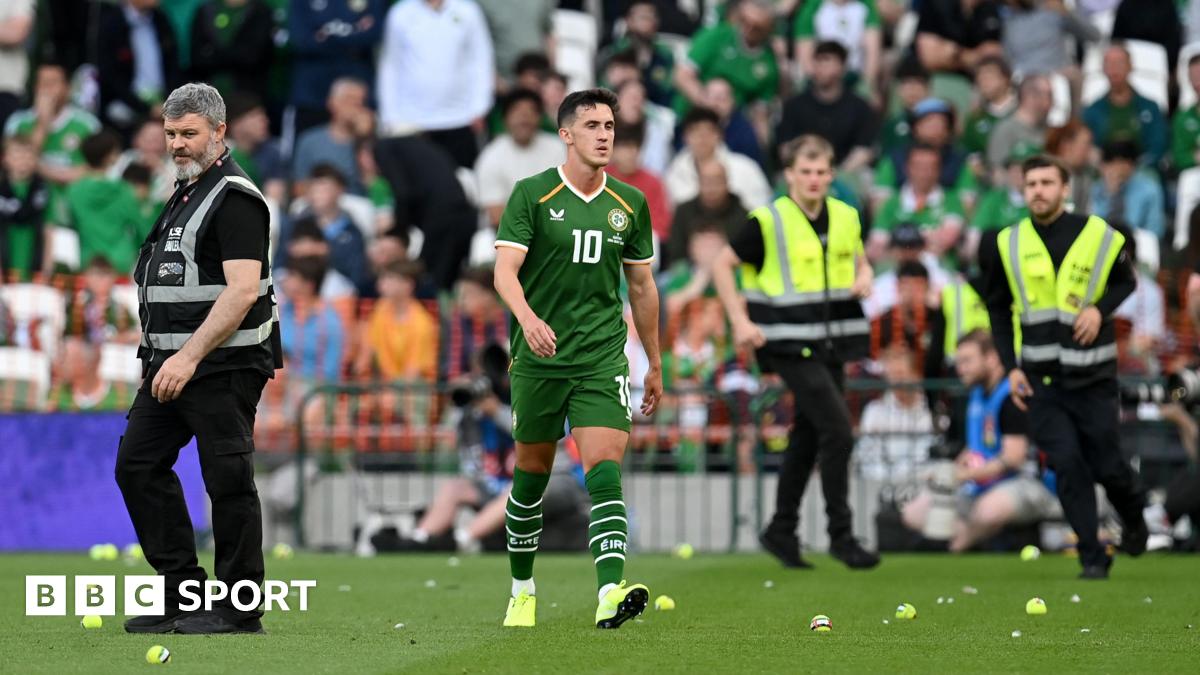 Jamie McGrath walks between tennis balls during the protest