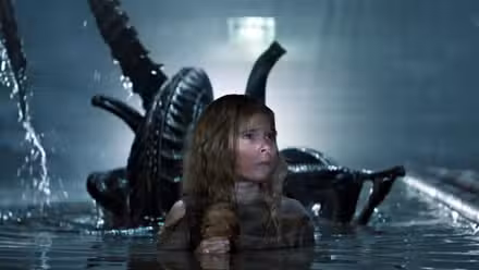 Newt (Carrie Henn) in a pool with the xenomorph behind her in 'Aliens'