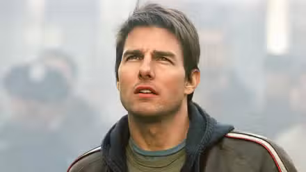 Tom Cruise as Ray Ferrier looks up, a crowd behind him in 'War of the Worlds'