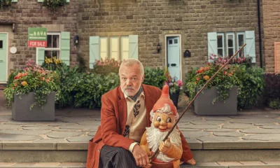 Graham Norton cosies up to a gnome on the set of his new series The Neighbourhood