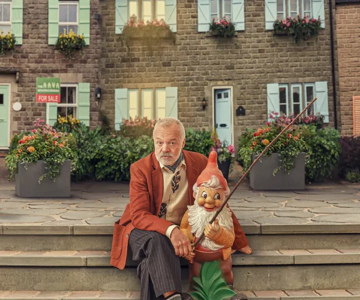 Graham Norton cosies up to a gnome on the set of his new series The Neighbourhood