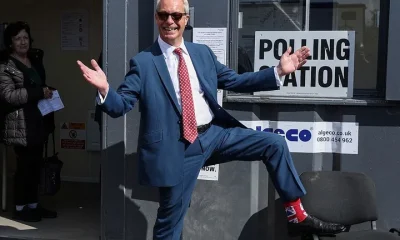 Reform UK leader Nigel Farage poses to show off his socks as he visits a polling station in Walton-on-the-Naze.