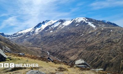 Photograph of a mountain with snow on the peaks along with sunny spells