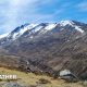 Photograph of a mountain with snow on the peaks along with sunny spells