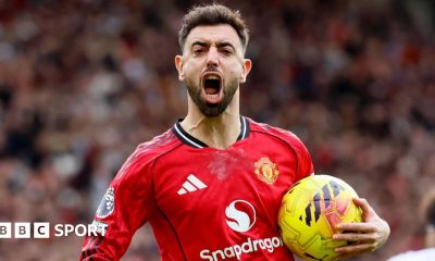 Bruno Fernandes celebrates a goal for Manchester United, with his mouth wide open and the ball in his left hand