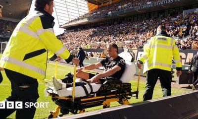 Xavi Simons being wheeled down a touchline on a stretcher