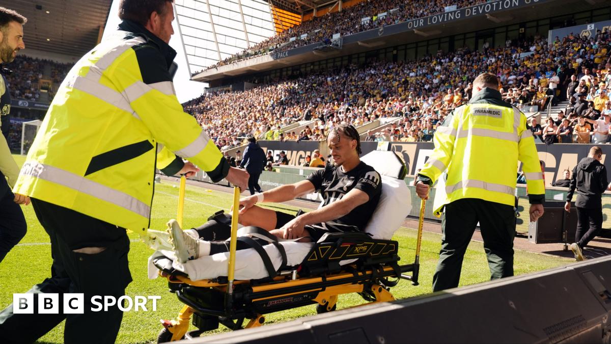 Xavi Simons being wheeled down a touchline on a stretcher