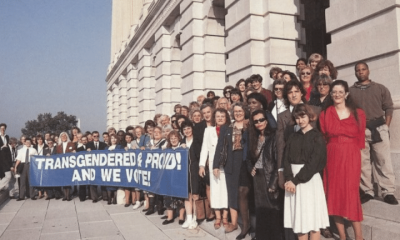 Archive photo of a line of people holding a banner that says 'Transgender and proud! And we vote'.