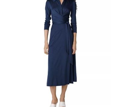 A woman wearing a dark blue midi dress and white slides