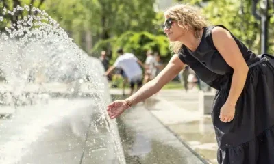 A woman cools down at a city centre cooling fountain Climate adaptation