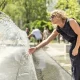 A woman cools down at a city centre cooling fountain Climate adaptation