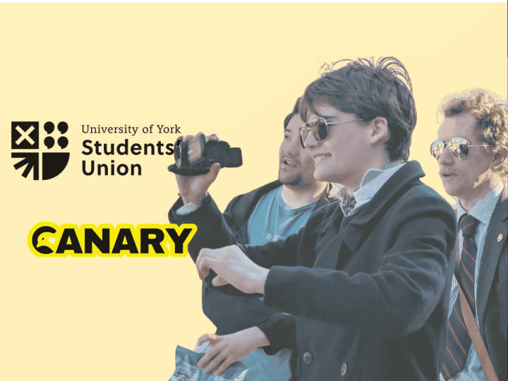 A picture of a Restore Britain Society fan holding a camera. On the left are both the University of York Student Union Logo and the Canary UK logo