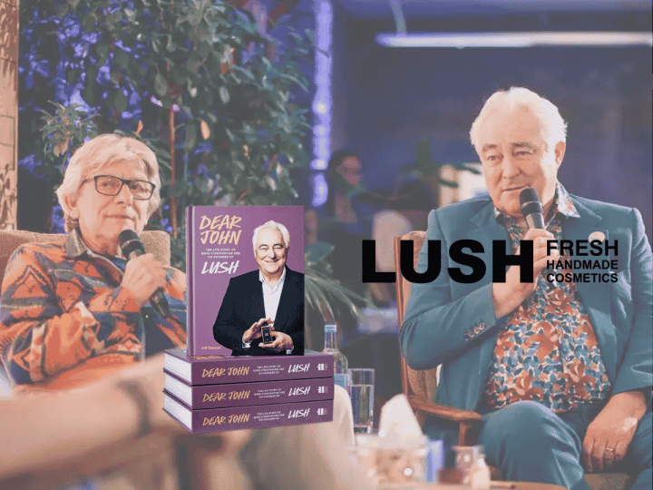 Mark Constantine and Jeff Osment talking at the book launch. In the foreground is a stack of the book 'dear John' and the LUSH logo