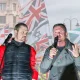 Tommy Robinson in front of various flags