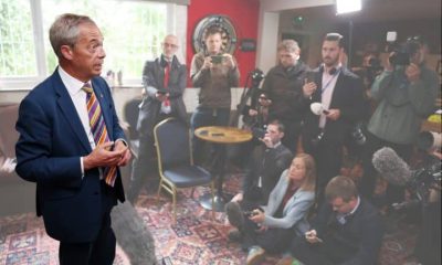 Reform leader Nigel Farage in a room full of journalists