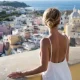 Woman enjoying the view of the idyllic port of Corricella, Procida Island, Italy
