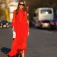 Alba Garavito Torre wears black sunglasses from Ray Ban, gold fringed metallic pendant earrings, a red with beige polka dots print pattern knot high neck / puffy sleeves / ruffled long dress from Zimmermann, gold bracelets, gold rings, a beige matte leather handbag from Jacquemus, gold shiny leather knot toe-cap block heels mules / sandals from What For, during a street style fashion photo session, on March 23, 2022 in Paris, France.